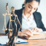 woman hand book with  justice lady on desk