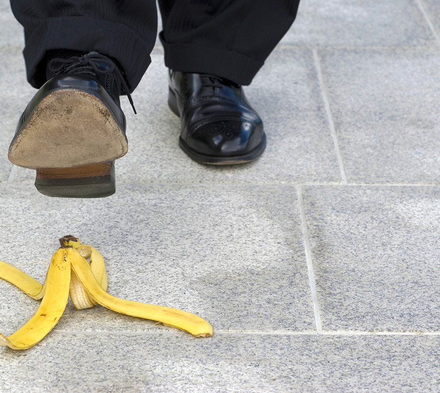 Businessman stepping on banana skin, copy space